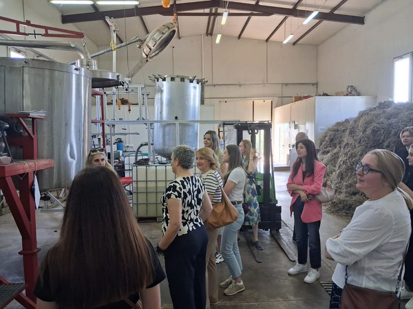 Group of people standing in a room next to a big tank.