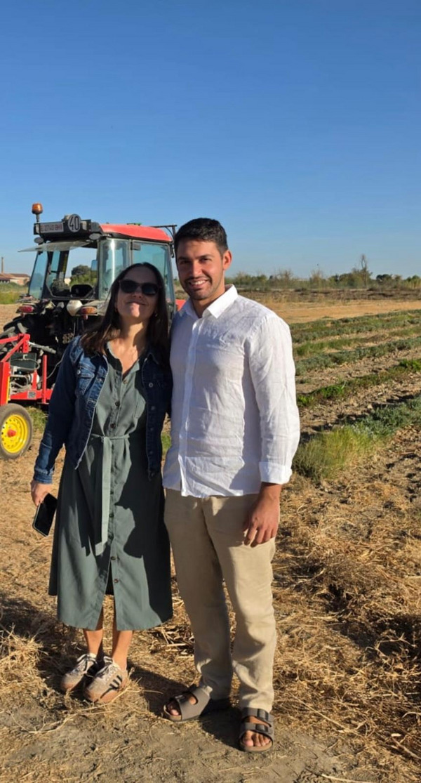 Portrait of two persons standing on a field. 