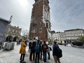 A group of people standing in front of an ancient tower.