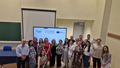 Group of people standing before a projection of the weedingMAPs project.