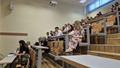 Group of people sitting in a lecture hall.